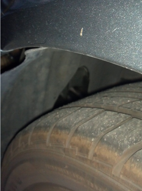 Here you can see where the tire rubbed out a nice hole.  When I ran over (whatever it was) it pushed the piece against the tire. I didn't know until I got to my destination and poped it back into position as best I could.